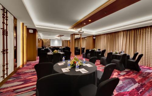 a conference room with tables and chairs and a screen at The Fern - Goregaon in Mumbai