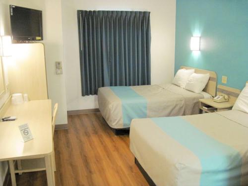 Habitación de hotel con 2 camas y escritorio en Motel 6-Avoca, IA en Avoca