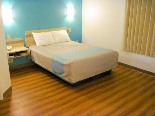 1 dormitorio con 1 cama y suelo de madera en Motel 6-Avoca, IA en Avoca