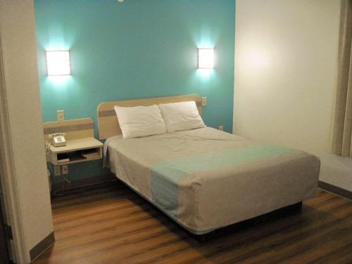 1 dormitorio con 1 cama con pared verde en Motel 6-Avoca, IA en Avoca