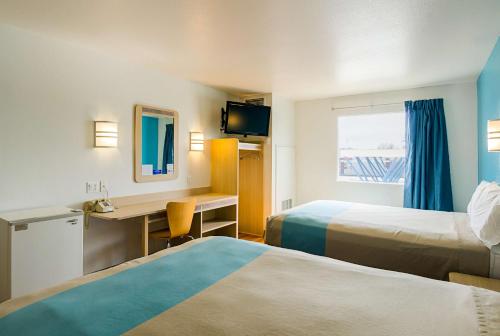 um quarto de hotel com duas camas e uma secretária em Motel 6-Wheatland, WY em Wheatland