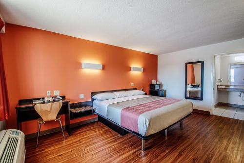 um quarto com uma cama e uma secretária e uma cama sidx sidx em Motel 6-Martinsburg, WV em Falling Waters
