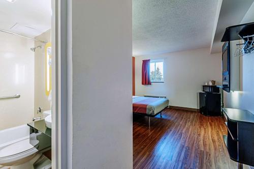 Habitación pequeña con cama y baño. en Motel 6-Martinsburg, WV, en Falling Waters