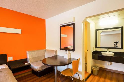 a room with a table and a mirror and a sink at Motel 6-Blue Springs, MO in Blue Springs