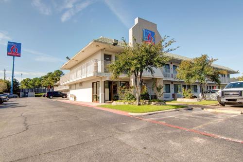 a building on the corner of a street with a parking lot at Studio 6-Grand Prairie, TX in Grand Prairie