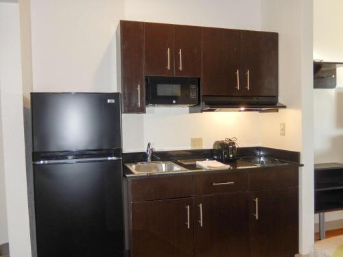 a kitchen with a black refrigerator and a sink at Studio 6-Yukon, OK in Yukon