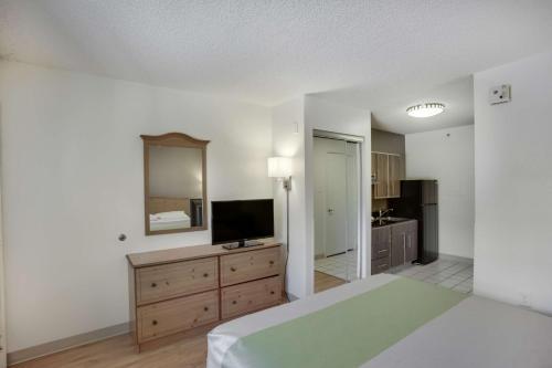 a large bedroom with a bed and a television at Studio 6-Stafford, TX - Houston - Sugarland in Stafford