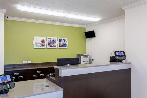 an office with a reception desk with a green wall at Studio 6-Albuquerque, NM - North in Albuquerque