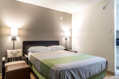 a hotel room with a bed and a chair at Studio 6-Dallas, TX - Northwest in Dallas