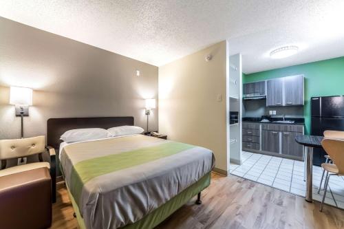 a hotel room with a bed and a kitchen at Studio 6-Dallas, TX - Northwest in Dallas