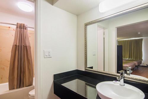 a bathroom with a sink and a mirror at Studio 6-Tyler, TX in Tyler