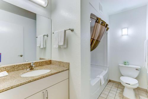a white bathroom with a toilet and a sink at Studio 6-Kissimmee, FL - Orlando in Orlando
