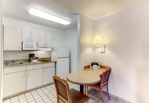 a small kitchen with a table and chairs in a room at Studio 6-Kissimmee, FL - Orlando in Orlando
