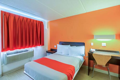 a bedroom with a bed and a desk and a red window at Ocean Inn South Padre Island in South Padre Island