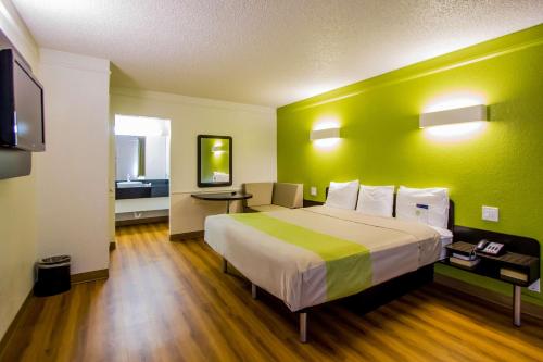 a bedroom with a large bed with a green wall at Motel 6-Austin, TX - Midtown in Austin