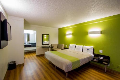 a bedroom with a large bed with a green wall at Motel 6-Austin, TX - Midtown in Austin