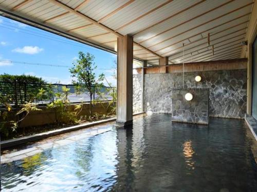 - une piscine d'eau dans une chambre dotée d'une grande fenêtre dans l'établissement Hotel Suimeikan, à Yamanouchi