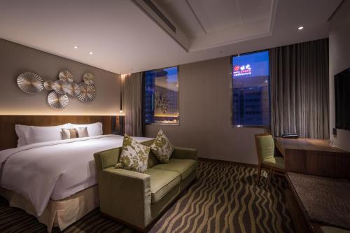Pokój hotelowy z łóżkiem, krzesłem i oknami w obiekcie Green World JianPei w Tajpej