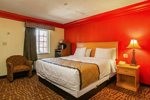 a bedroom with a bed and a red wall at Bay Side Inn & Suites in Aberdeen