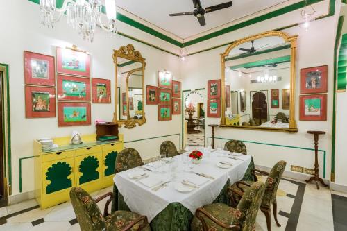 a dining room with a table and chairs and a mirror at Shiv Niwas Palace by HRH Group of Hotels in Udaipur