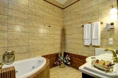 een badkamer met een bad en een wastafel bij Naiades Hotel Resort & Conference in Neochori