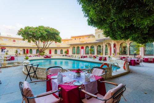a restaurant with tables and chairs in front of a pool at Shiv Niwas Palace by HRH Group of Hotels in Udaipur