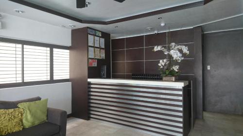 a lobby with a bar with a couch and windows at Calamba Pension Plaza in Calamba