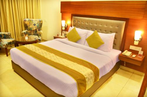 a hotel room with a large bed with yellow pillows at Mint Hotel Premia Chandigarh, Zirakpur in Chandīgarh