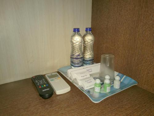 a table with two bottles and a remote control at Banyan Tree Comforts Mysore in Mysore