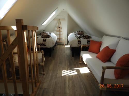 a attic room with two beds and a couch at Romala's Home in Kiel