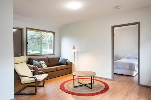 a living room with a couch and a bed at The Peaks Halls Gap in Halls Gap