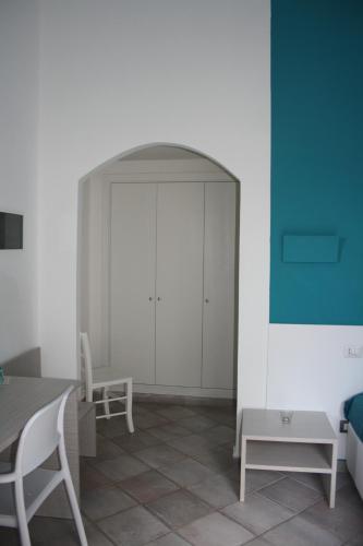 a living room with a table and a white wall at Da Nino sul mare Filicudi in Filicudi
