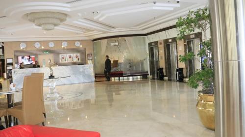 a lobby with a man standing in a building at Dubai Grand Hotel by Fortune, Dubai Airport in Dubai