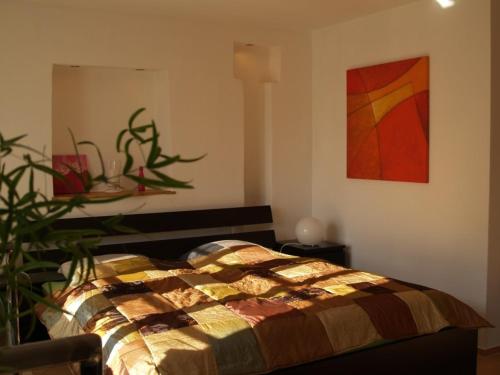 1 dormitorio con 1 cama y una pintura en la pared en Ferienwohnung Berweiler, en Schweich