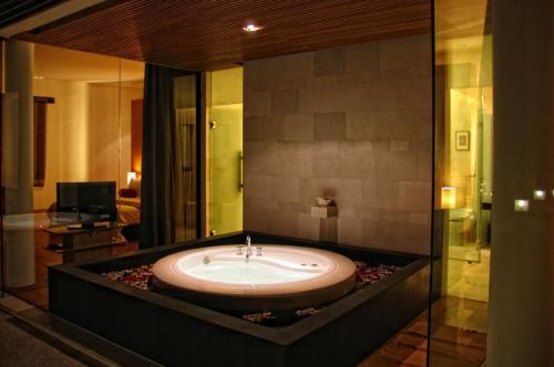 Cette chambre comprend une salle de bains pourvue d'une grande baignoire. dans l'établissement The Wangsa Benoa, à Nusa Dua