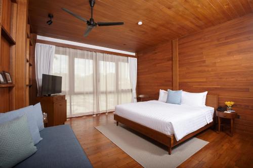 a bedroom with a bed and a flat screen tv at Chann Bangkok Noi in Bangkok