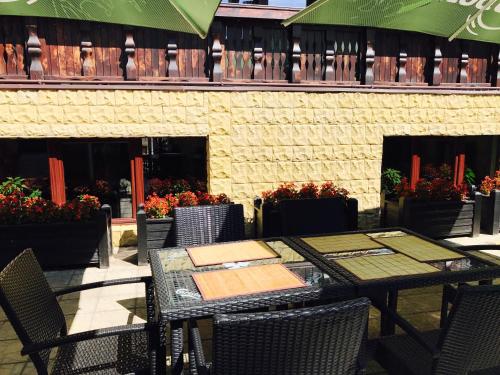 ein Tisch und Stühle auf einer Terrasse mit Blumen in der Unterkunft Casa Frent in Predeal