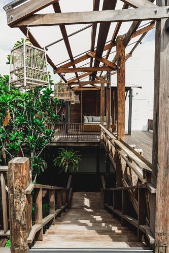 a wooden bridge leading to a bedroom on a house at Chann Bangkok Noi in Bangkok