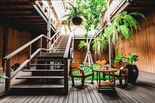 a patio with a staircase and a table and chairs at Chann Bangkok Noi in Bangkok