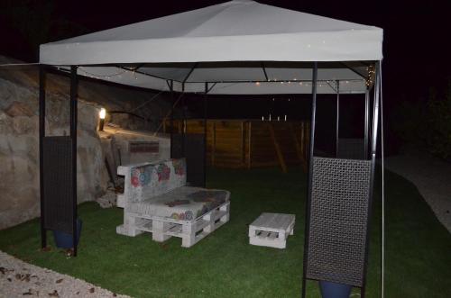 a gazebo with a couch and a chair under it at Mas del Fangaro in Benifallet