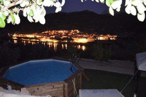 a hot tub with a view of a city at night at Mas del Fangaro in Benifallet