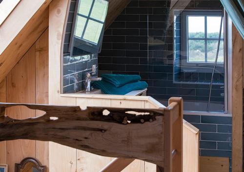 ein Bad mit einem Waschbecken und einem Spiegel in einem Haus in der Unterkunft Le Pilleur d'Epaves in Cléden-Cap-Sizun