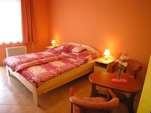een slaapkamer met een bed en een tafel en stoelen bij Cserkeszőlőszállások-Hőforrásszállások in Cserkeszőlő