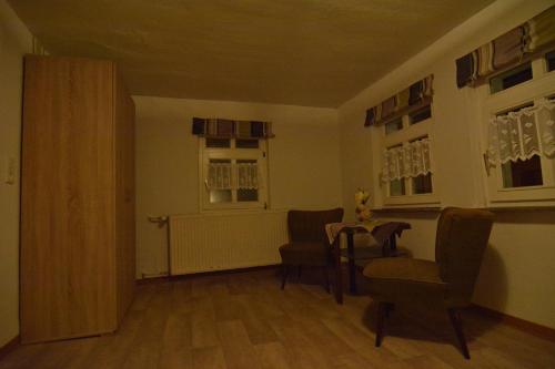 a living room with a table and chairs and a window at Traditionsgasthof Zum Luedertal in Bimbach