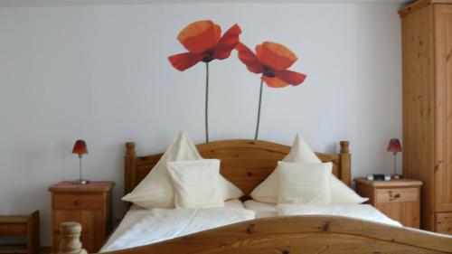 a bedroom with a bed with flowers on the wall at Hotel Andreasstuben in Weißenburg in Bayern