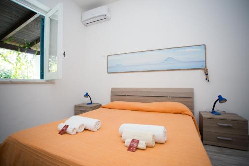 1 dormitorio con 1 cama con 2 toallas en Titina Village Porto, en Vulcano