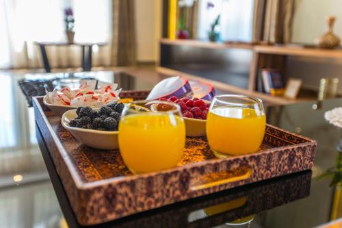 a tray of fruit and juice on a table at Villa Rose in Sarajevo