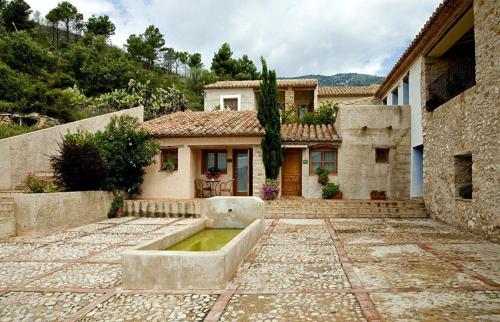 a house with a fountain in front of it at Aldea Roqueta Hotel Rural in Els Ibarsos