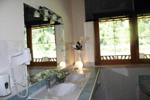 ein Badezimmer mit zwei Waschbecken und einem großen Spiegel in der Unterkunft Landhaus Chalet Rosenrot in Fügen