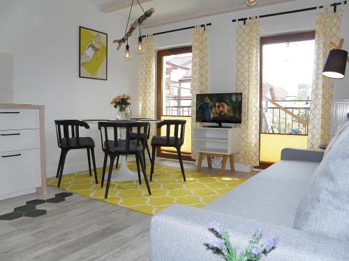 a living room with a table and chairs and a tv at Aloza in Ustka